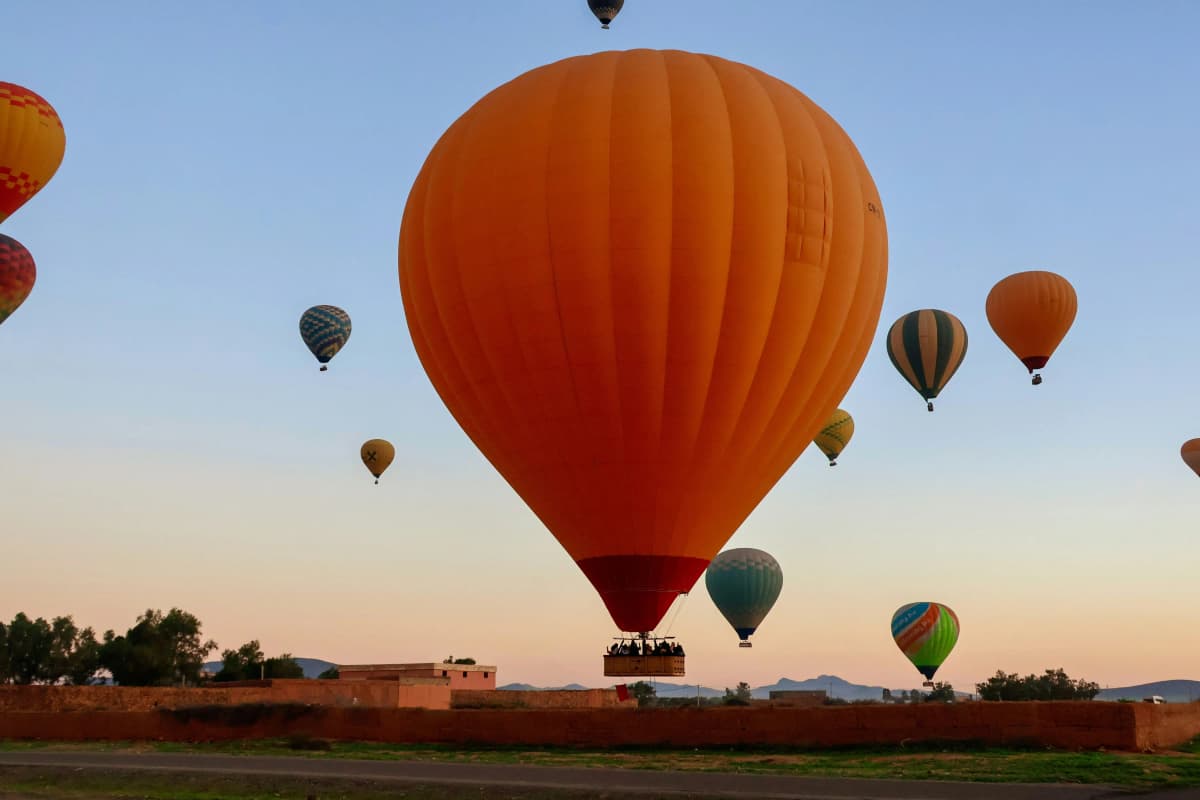 Hot air balloons flying above the Marrakech countryside at sunrise
